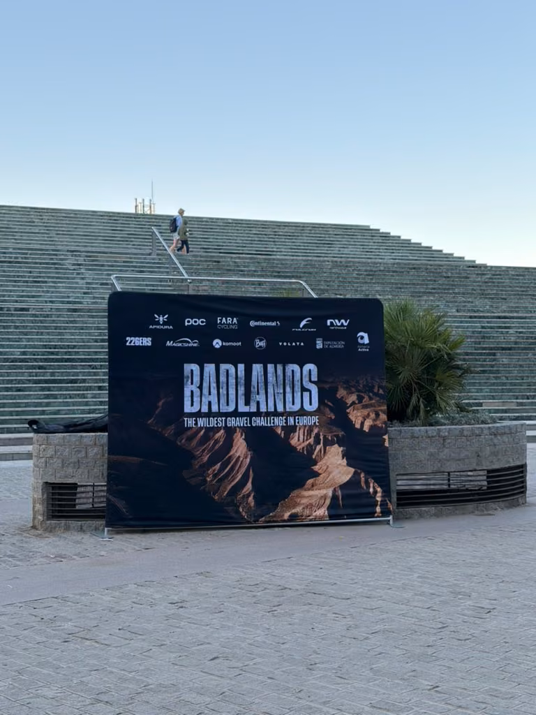 A Badlands backdrop stands at the foot of broad stone steps, with blue sky above.